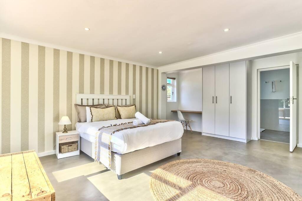 a bedroom with a large bed and a table at Family Home, WiFi, Patio, Secure Parking in Cape Town