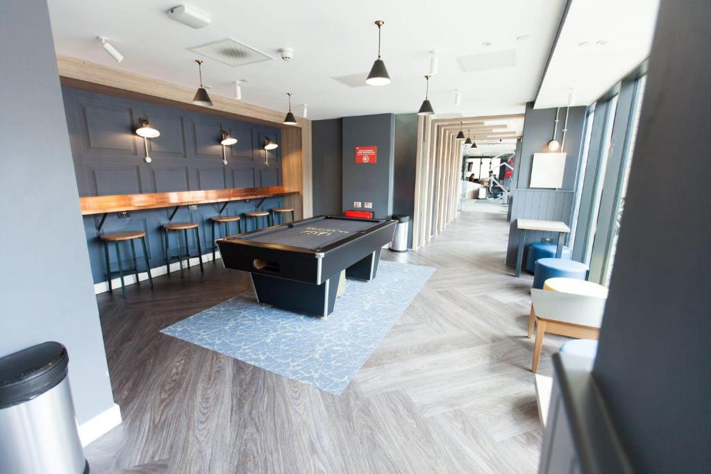 a salon with a ping pong table and chairs at For Students Only Stylish Studio Apartments at Crown Place in Portsmouth in Portsmouth