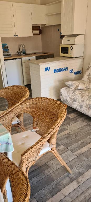 a kitchen with two wicker chairs and a mattress at " Au Morgan de vous " in Le Lavandou