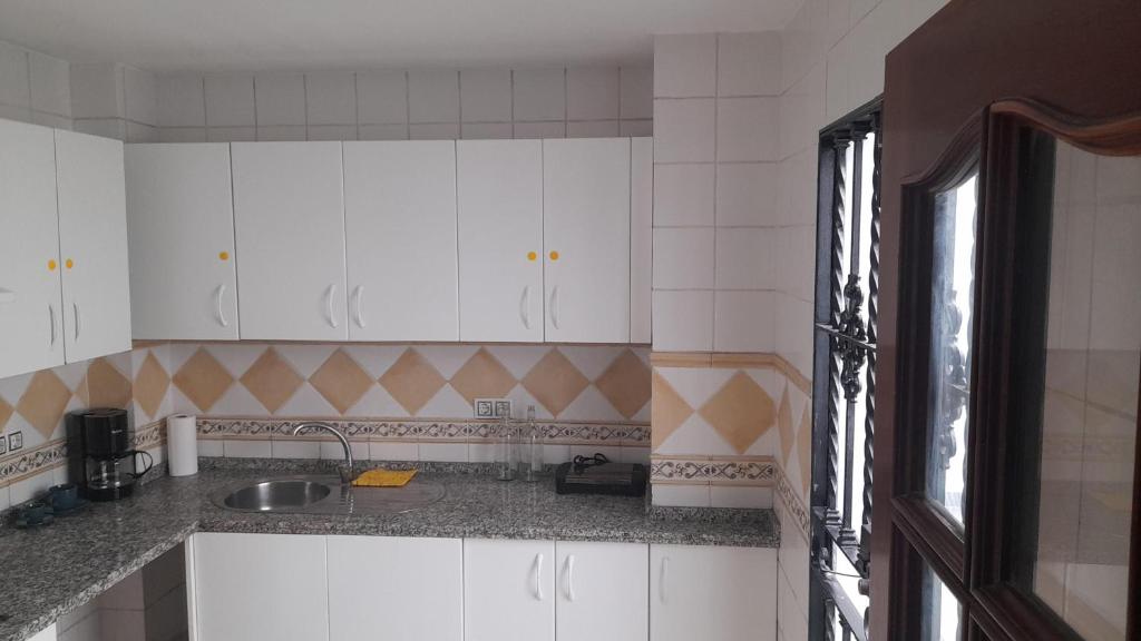 a kitchen with white cabinets and a sink at CASA INDEPENDIENTE EN NERVION JUNTO A PARADA DEL METRO in Seville