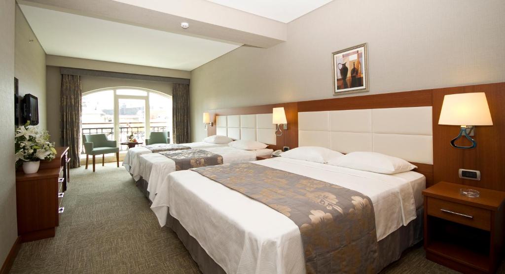 a hotel room with two beds and a window at Innpera Hotel in Istanbul