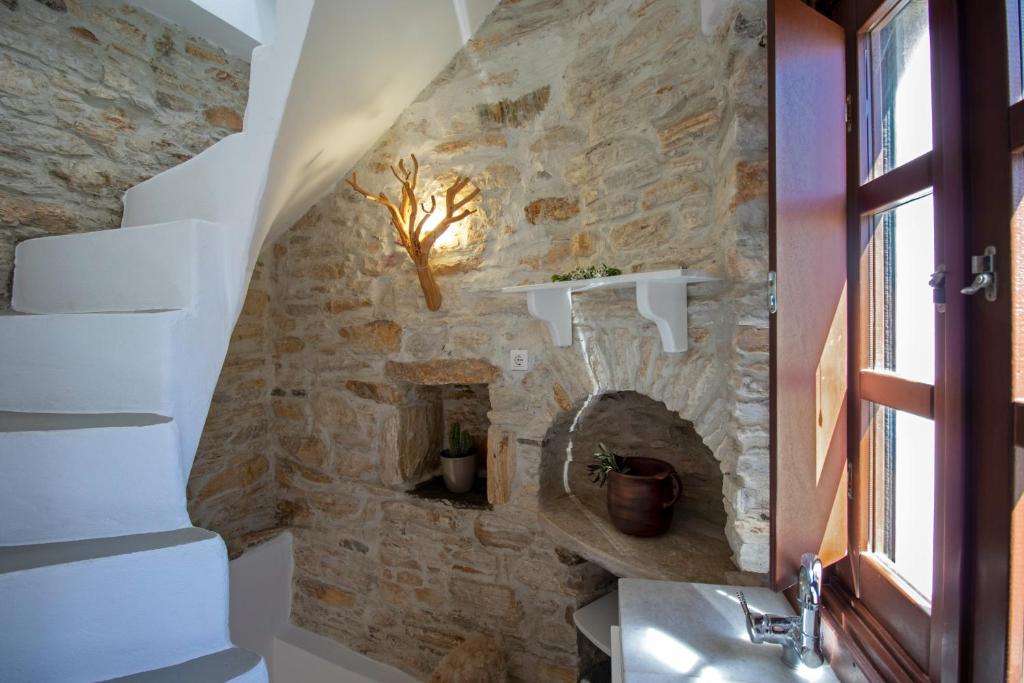 a bathroom with a stone wall and a sink at Platsa's House in Apeiranthos