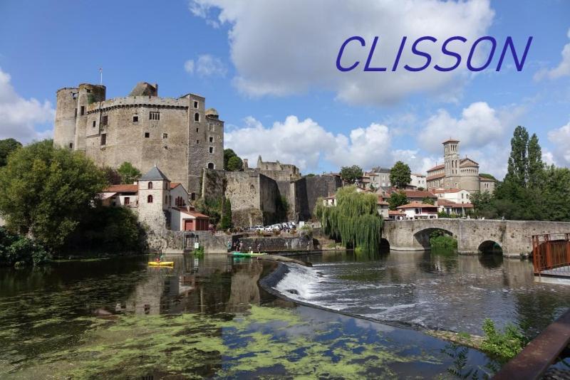 uma vista para um castelo e um rio com uma ponte em HEUREUX HASARD em Clisson