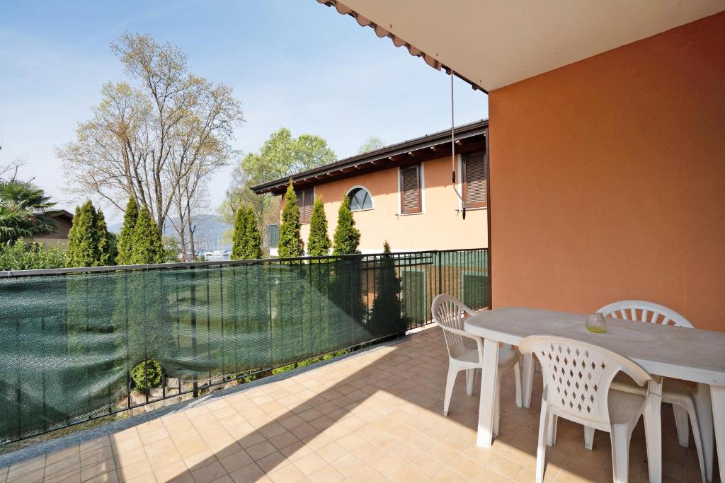 patio con tavolo, sedie e recinzione di Appartamento Matilde a  Monvalle 