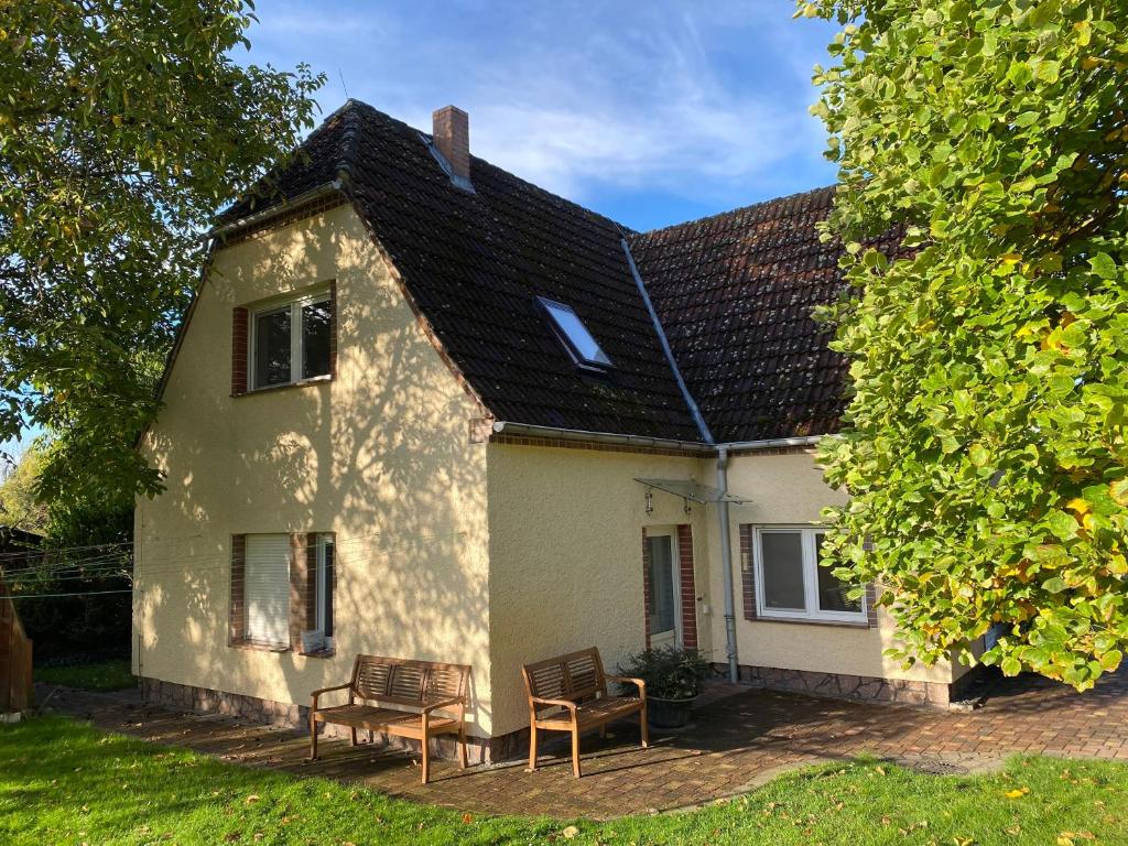 ein weißes Haus mit zwei Stühlen davor in der Unterkunft Ferienhaus Spreewald in Luckau