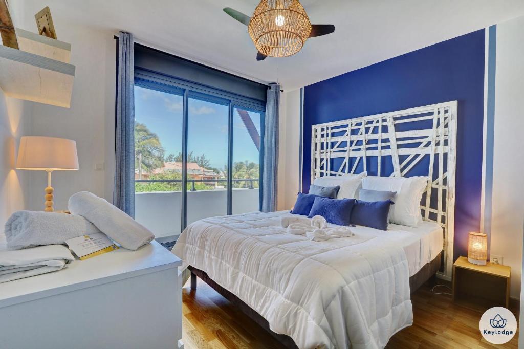 a bedroom with a white bed and a large window at Ocean Cottage 3 étoiles - 50 m2 - Etang Salé Les Bains in Étang-Salé les Bains