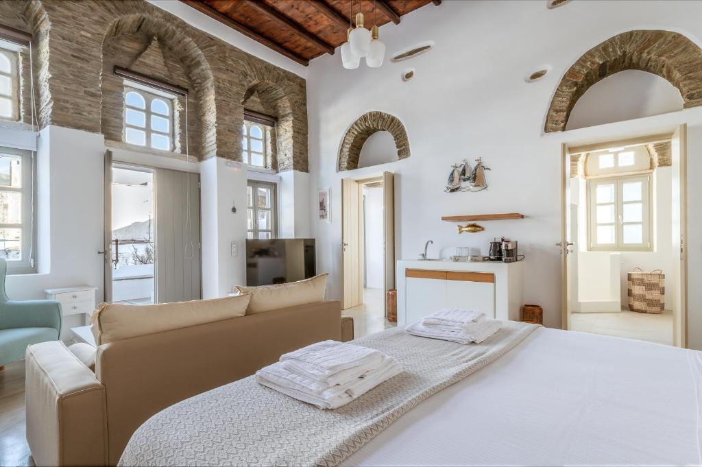 1 dormitorio grande con 1 cama y 1 sofá en Ursa Major Suites, en Tinos