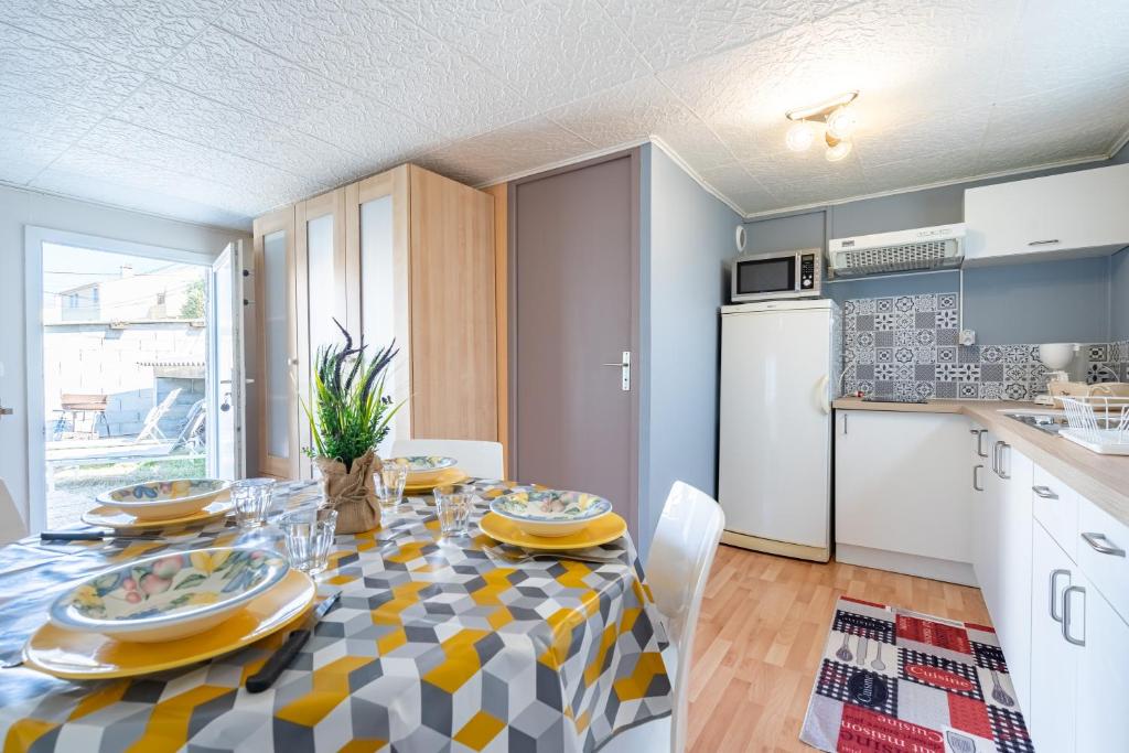 una cucina e una sala da pranzo con tavolo e sedie di Le Quiloé a Frontignan