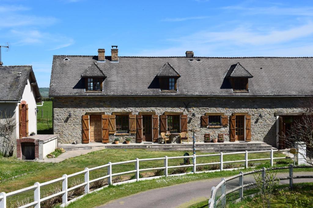 una vieja casa de piedra con una valla blanca en Le Chêne d’Or, en Marcheseuil