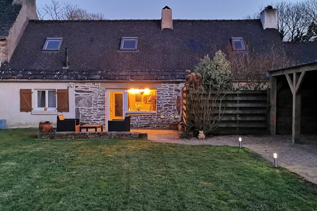a stone house with a patio in the yard at Petite maison dans les Monts d'Arrée TY COZ in Commana
