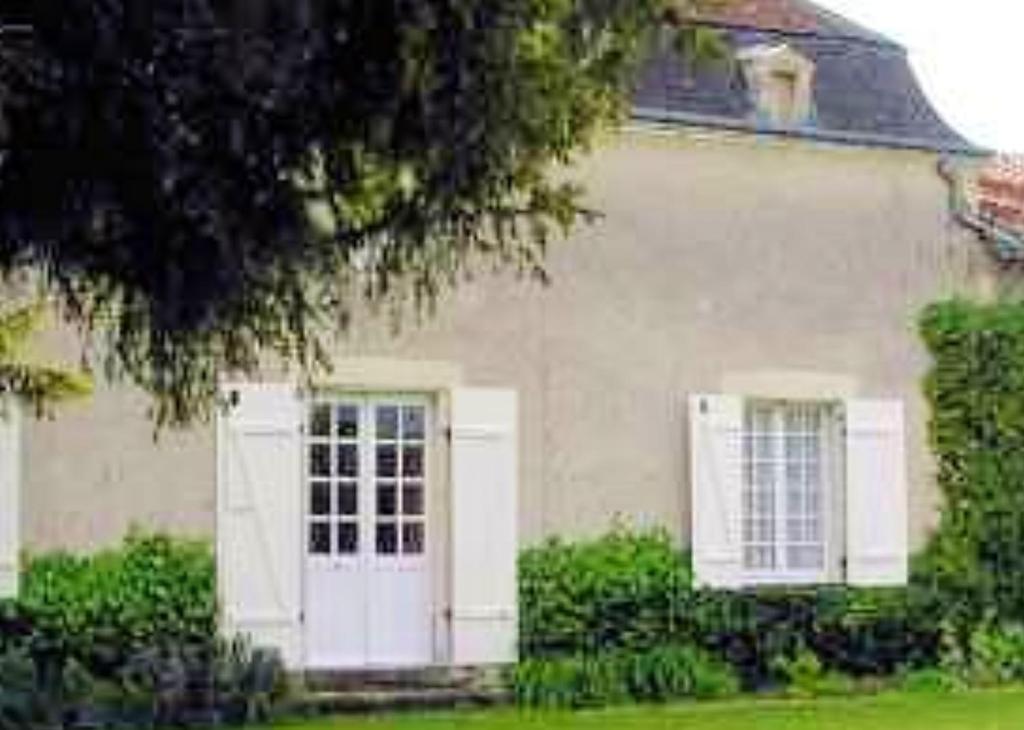 a white house with white doors and windows at Maison familiale paisible proche de Braslou + jardin spacieux in Braslou