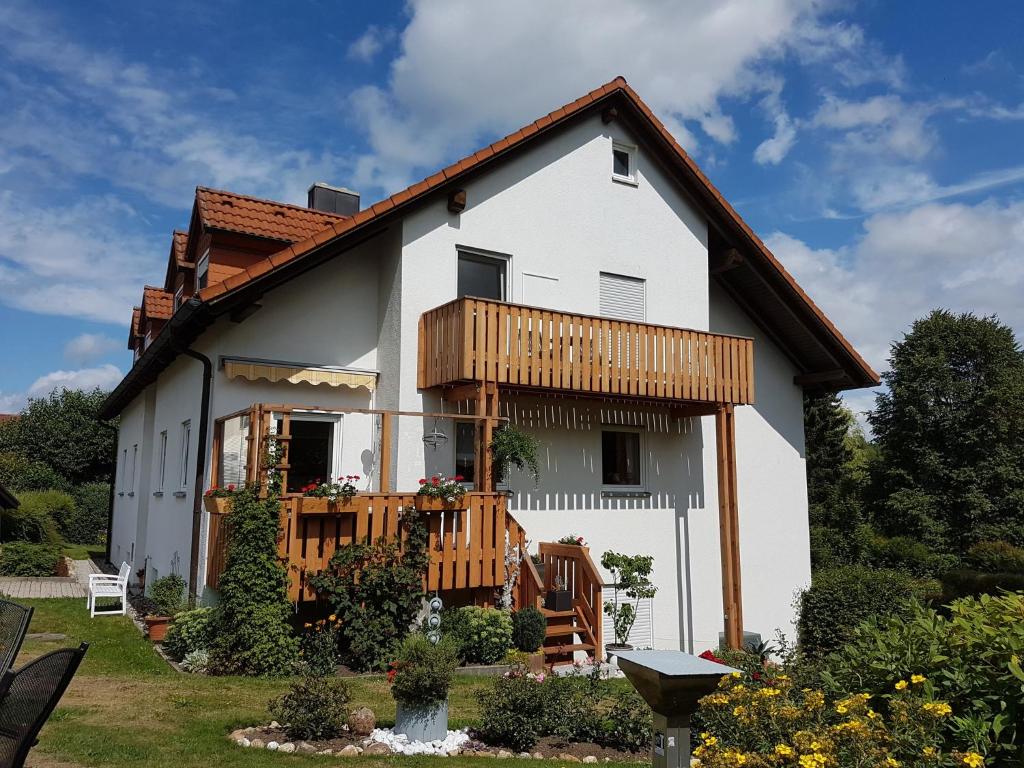 a white house with a balcony on the side at Ferienwohnung - a67145 in Mehlmeisel