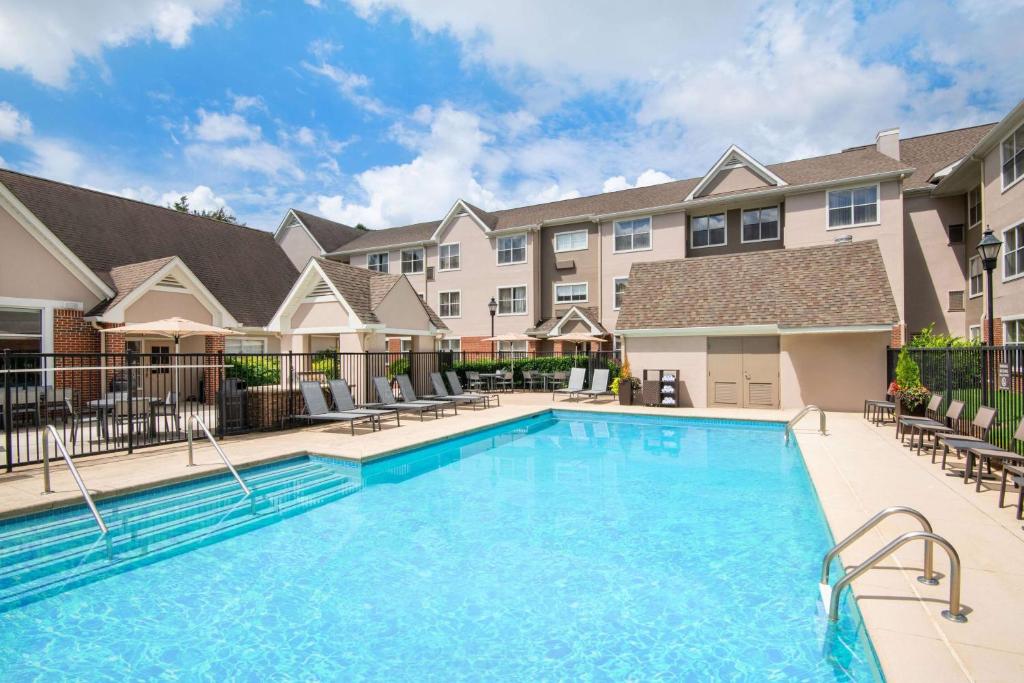 una piscina en un apartamento con sillas y un edificio en Sonesta ES Suites Atlanta Kennesaw Town Center, en Kennesaw