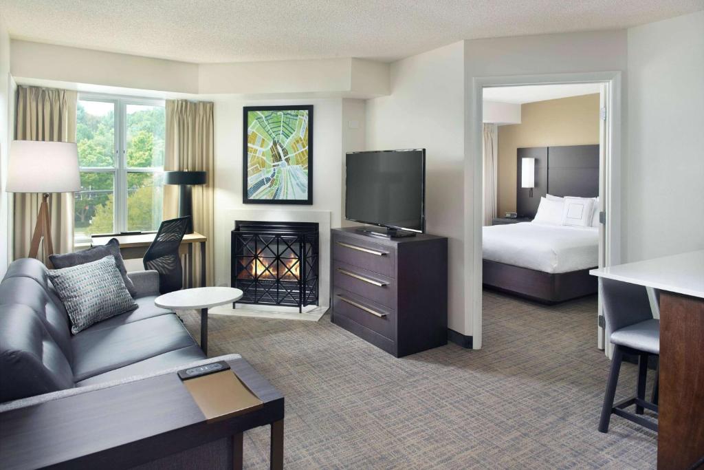 une chambre d'hôtel avec un canapé, un lit et une télévision dans l'établissement Sonesta ES Suites Raleigh Cary, à Cary