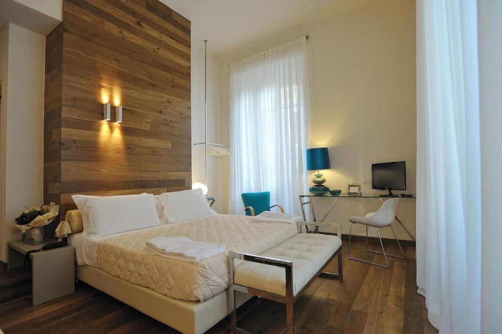 sypialnia z łóżkiem, biurkiem i telewizorem w obiekcie Luxury B&B La Dimora Degli Angeli we Florencji