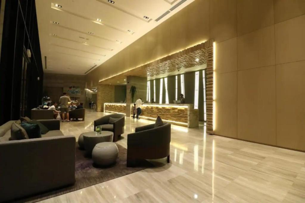 a lobby with couches and chairs in a building at Maxhome at Fraser Residence KL in Kuala Lumpur