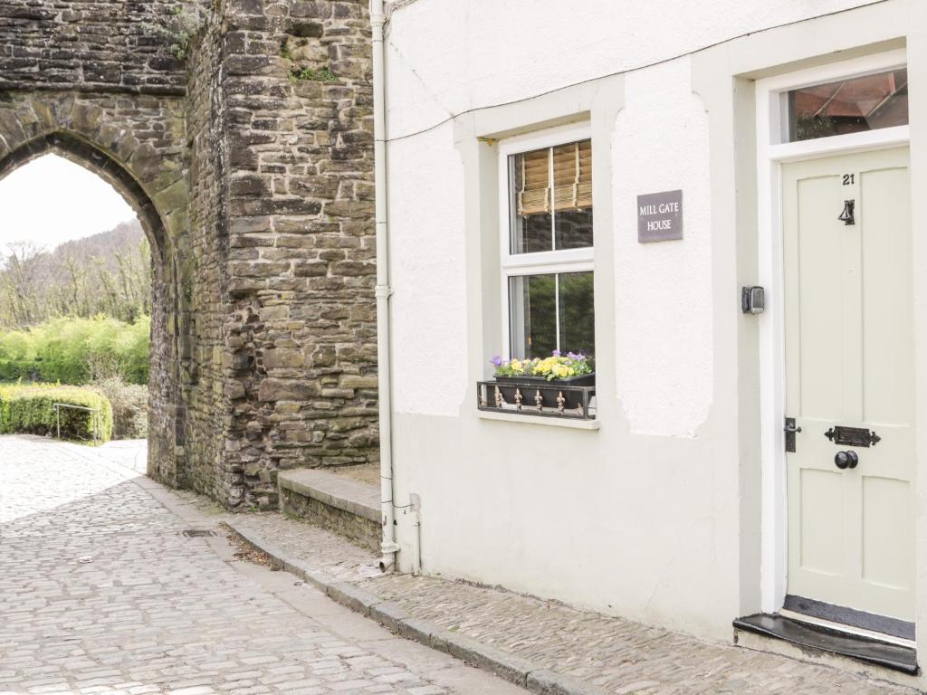 a white building with a window with flowers in a window box at Millgate House in Conwy