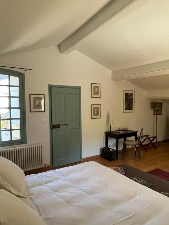 ein Schlafzimmer mit einem weißen Bett und einem Tisch in der Unterkunft Face au Palais in Avignon