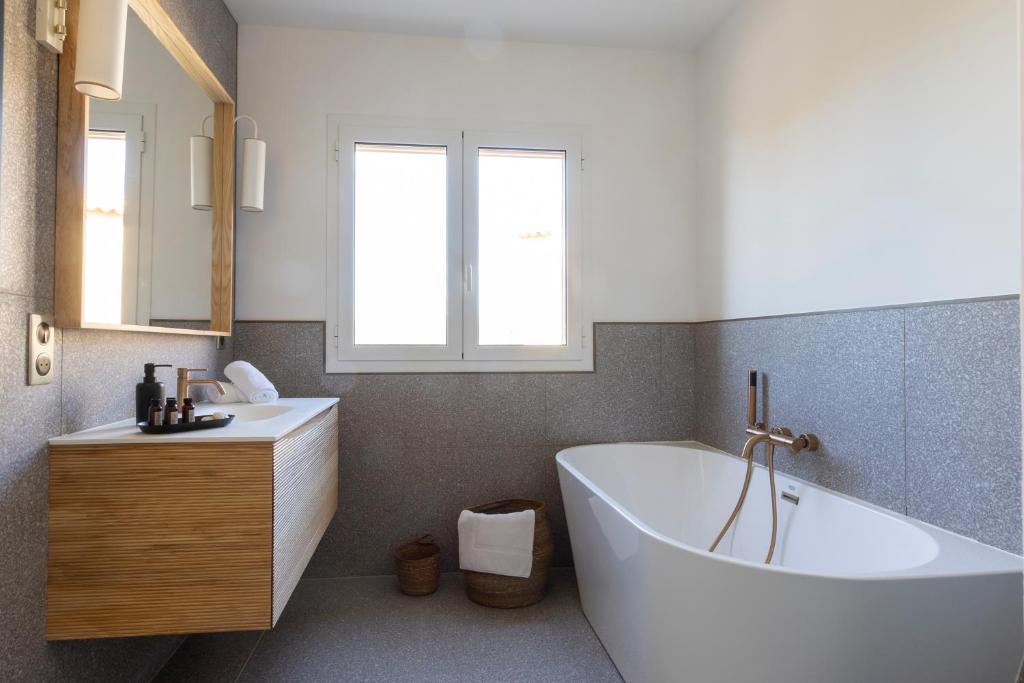 a bathroom with a large white tub and a sink at Résidence Omigna in Cargèse
