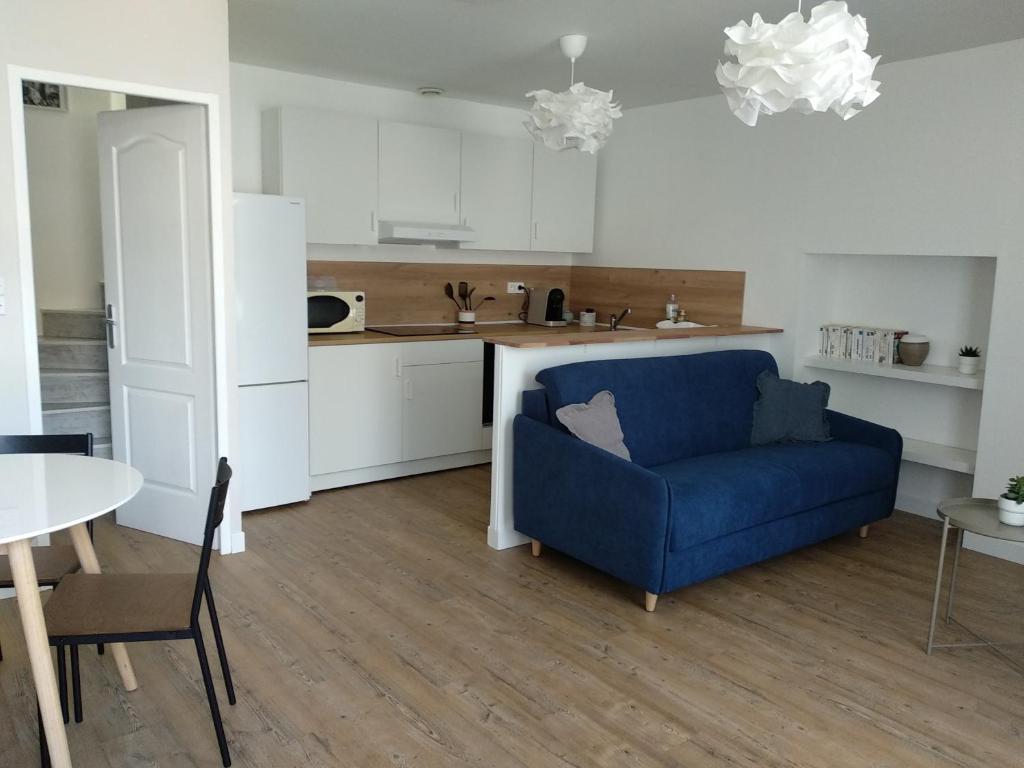 sala de estar con sofá azul y cocina en La Petite Maison en Rezé
