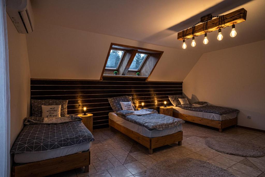 a room with two beds and a window and lights at Apartamenty Na Szlaku in Iwonicz-Zdrój