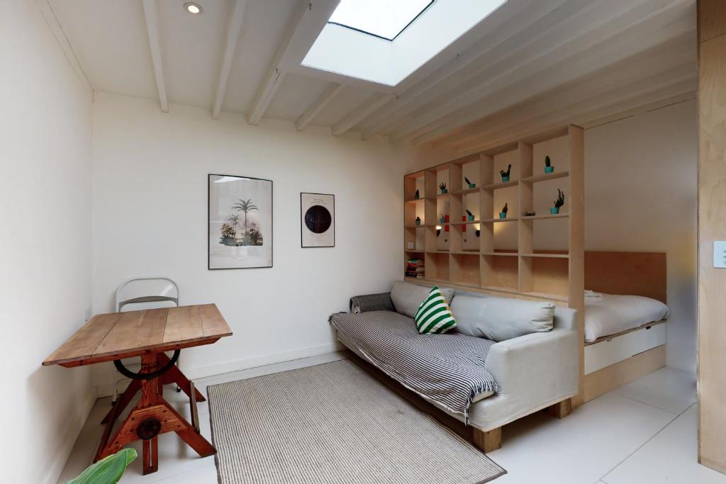 een woonkamer met een bank en een tafel bij Spacious studio flat in Forest Gate in Londen