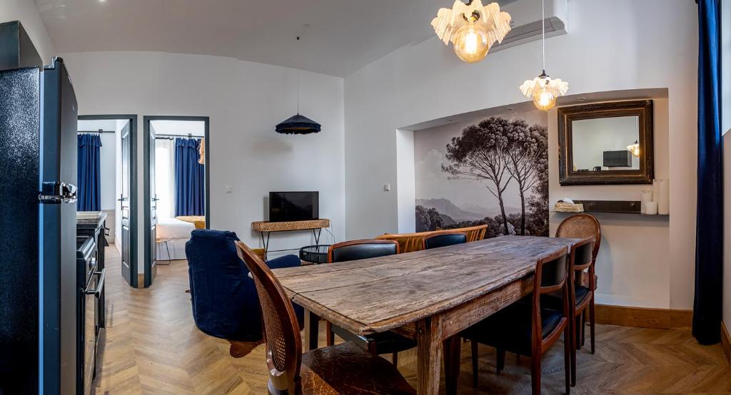 een eetkamer met een houten tafel en stoelen bij Maison Gaspard - Suites et appartements de charme à Saumur in Saumur