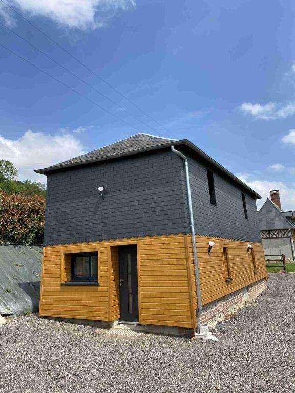 une petite maison avec un toit noir dans l'établissement La Maison de FRED, à Tourville-sur-Pont-Audemer