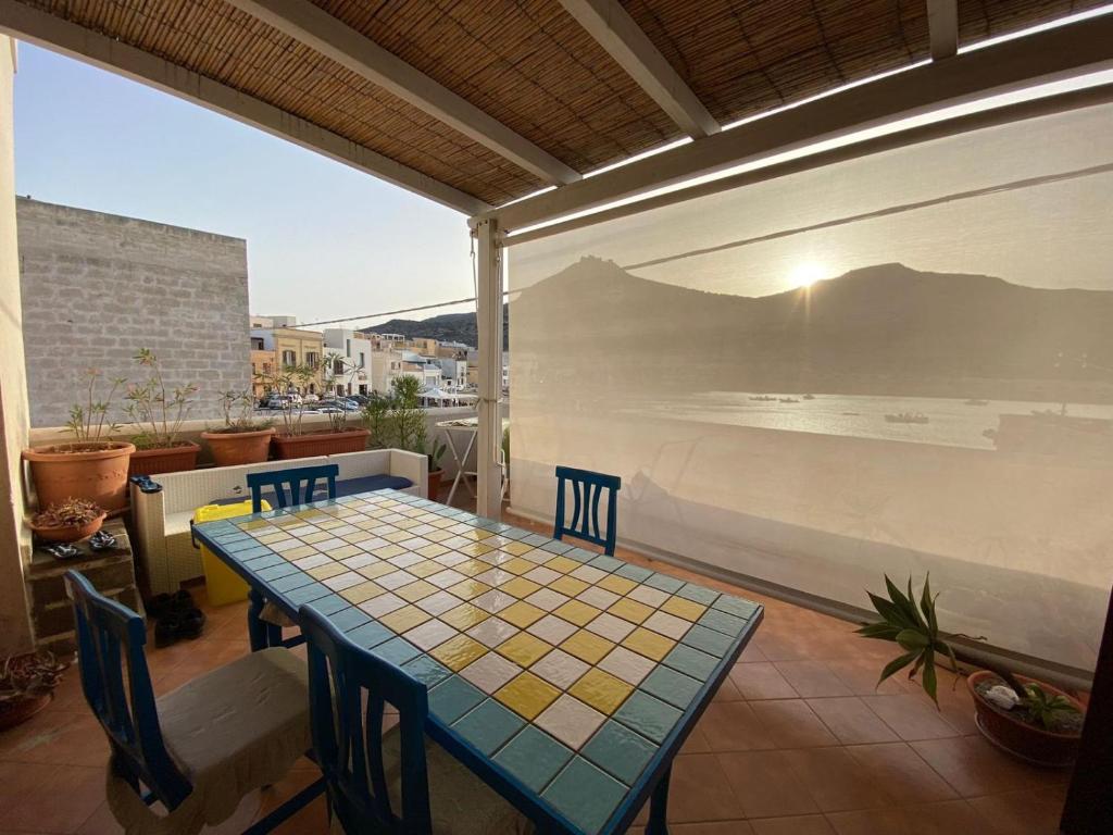 een tafel en stoelen op een patio met uitzicht op de oceaan bij Casa Emma in Favignana