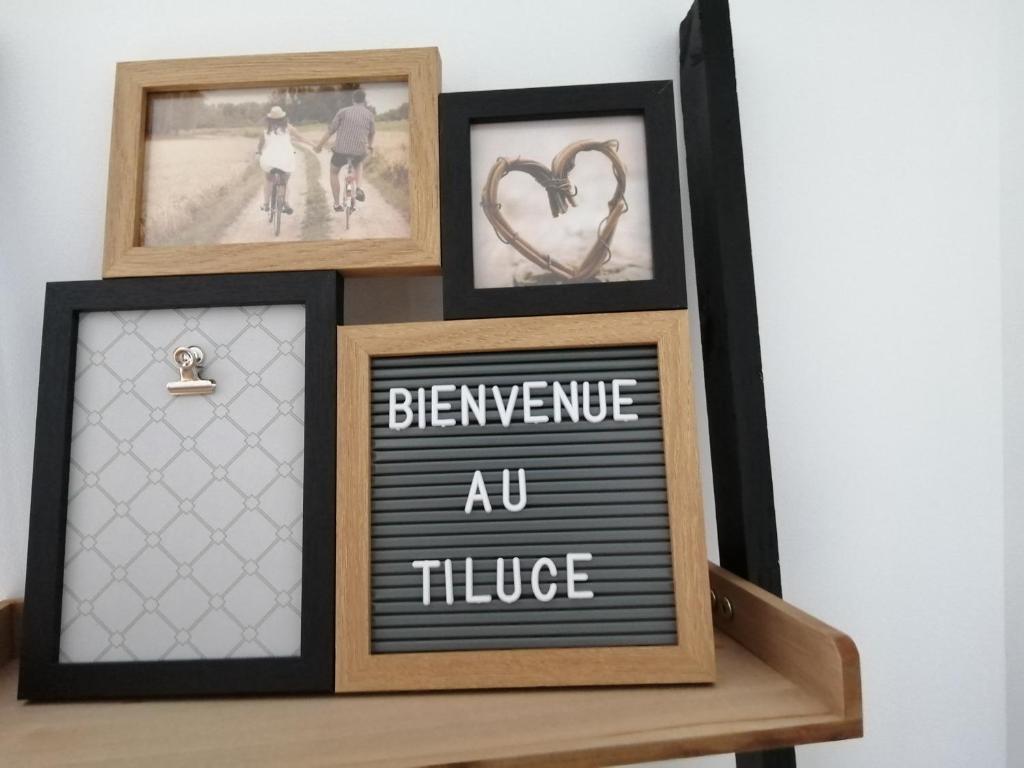 un estante con tres cuadros y una pizarra con una colmena au house en Le Tiluce, en Aunay-sur-Odon