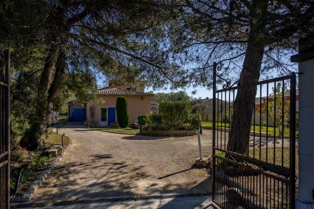 een poort naar een huis met een oprit bij La Rose Des Vents in Modène