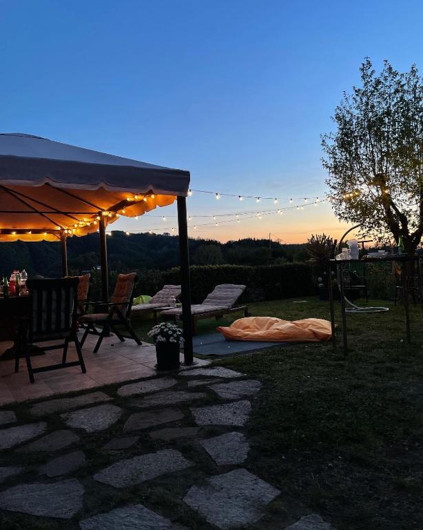 patio ze stołem i krzesłami pod namiotem w obiekcie B&B Codivilla w mieście Sasso Marconi