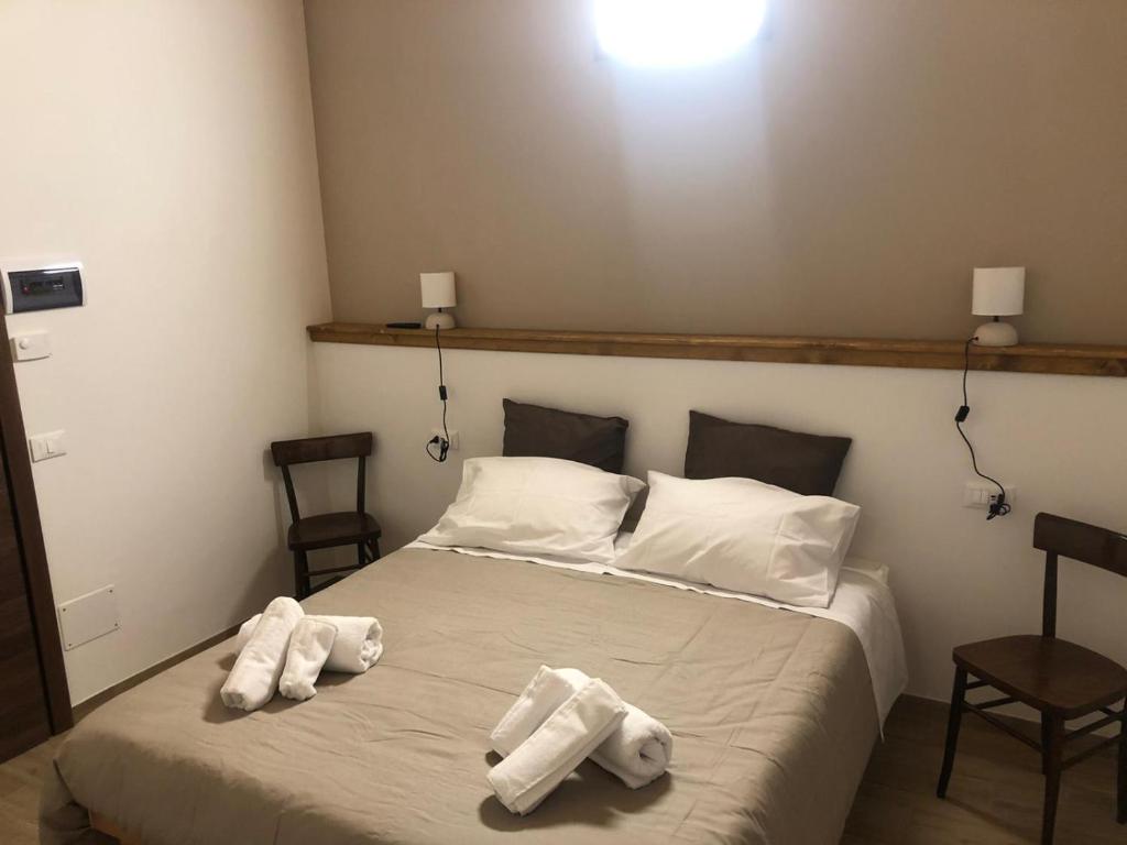 1 dormitorio con 1 cama con toallas en Agriturismo NONNU LUI`, en Amandola