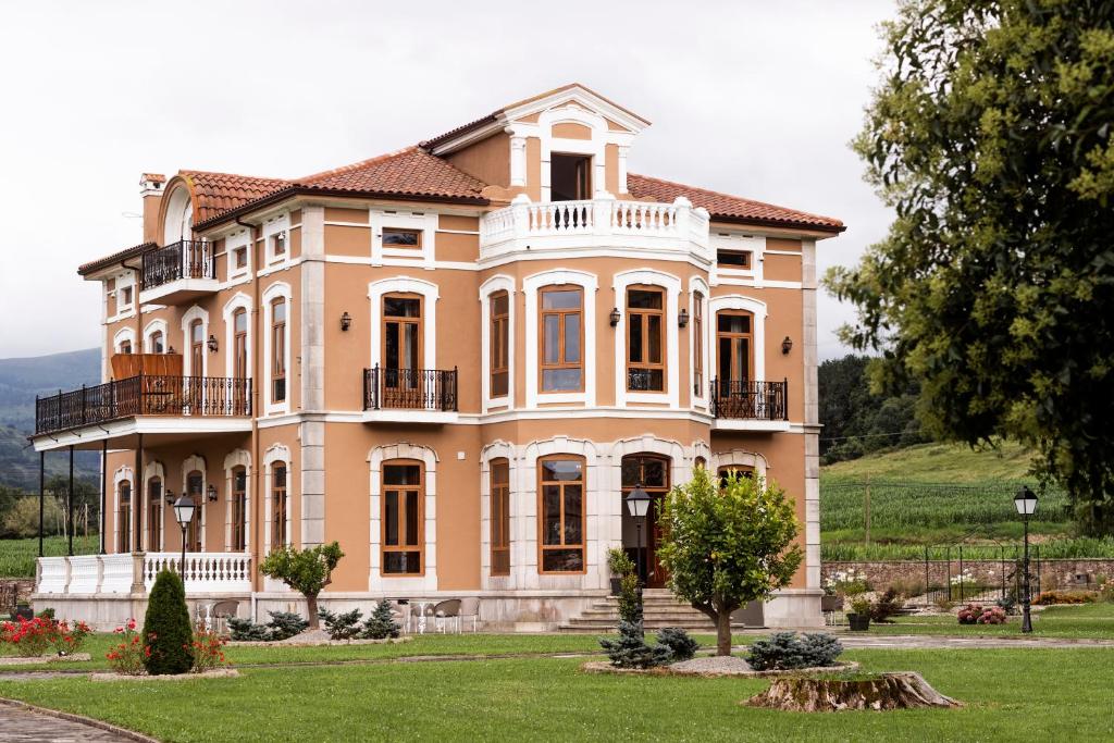 uma grande casa cor de pêssego com um quintal em POSADA SEMILLA em La Abadilla