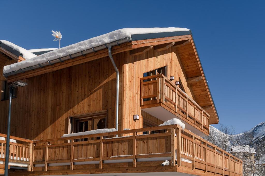 Cabaña de madera con nieve en el techo en Le Refuge des Sens chalet Quiétude, en Vaujany
