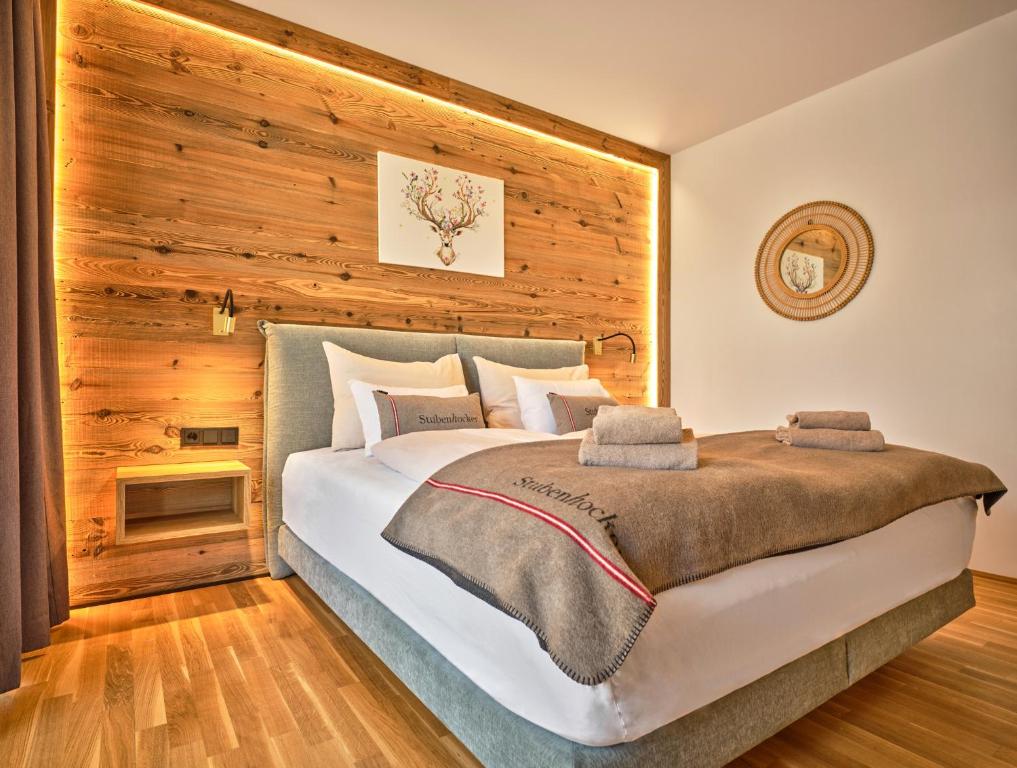 ein Schlafzimmer mit einem großen Bett und einer Holzwand in der Unterkunft The Spa Suite Top 3- Tauplitz Residences by AAHH in Tauplitz