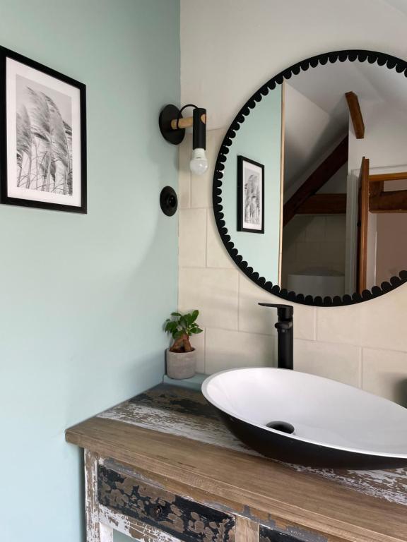 ein Badezimmer mit einem Waschbecken und einem Spiegel auf der Theke in der Unterkunft Chez Malouga 