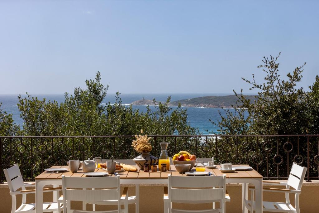 a dining table with a view of the ocean at Résidence Omigna in Cargèse