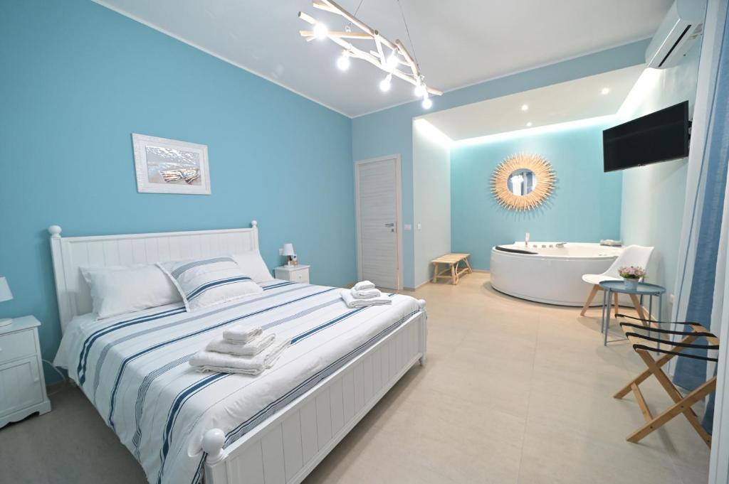 um quarto com uma cama, uma banheira e um lavatório em Villa Borgo dei Pescatori em Torre Faro