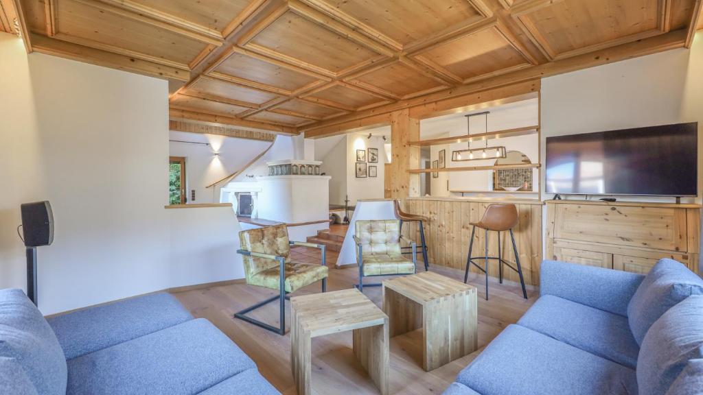 a living room with a blue couch and a kitchen at Chalet Lindau Fieberbrunn - by ONE VILLAS in Fieberbrunn