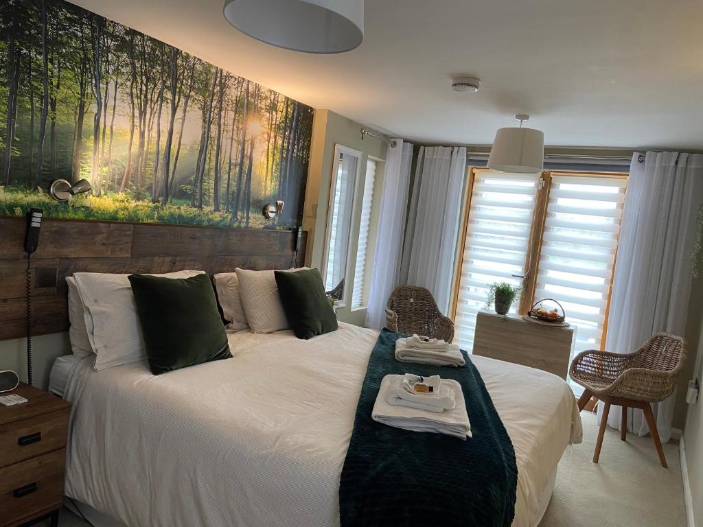 contemporary quiet countryside retreat في Horsley: غرفة نوم بسرير كبير مع صورة على الحائط
