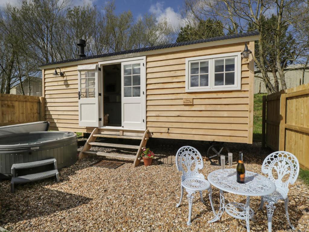 ein kleines Haus mit einem Tisch, Stühlen und einer Badewanne in der Unterkunft Cherry Blossom in Bristol