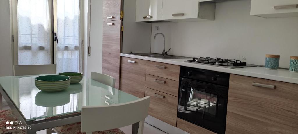 - une cuisine avec une table en verre et une cuisinière dans l'établissement Appartamento a due passi dal mare, à Cirò Marina