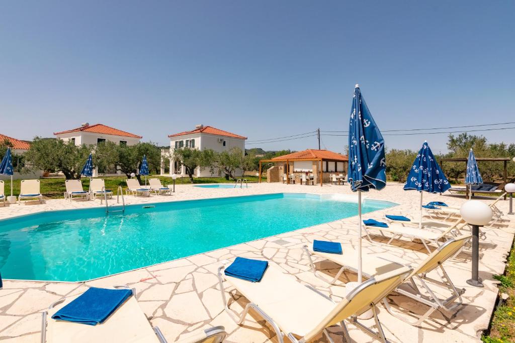 a pool with chairs and umbrellas at Lenna's Villas Zante in Vasilikos