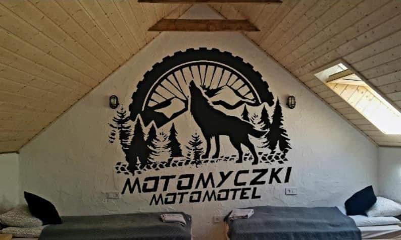 a wall with a mural of a wolf and a wheel at MotoMotel-Myczkowianka Sadyba in Myczkowce