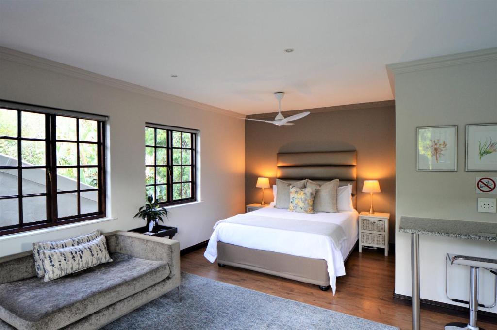 a bedroom with a white bed and a fireplace at Garden View Executive Suite in Johannesburg