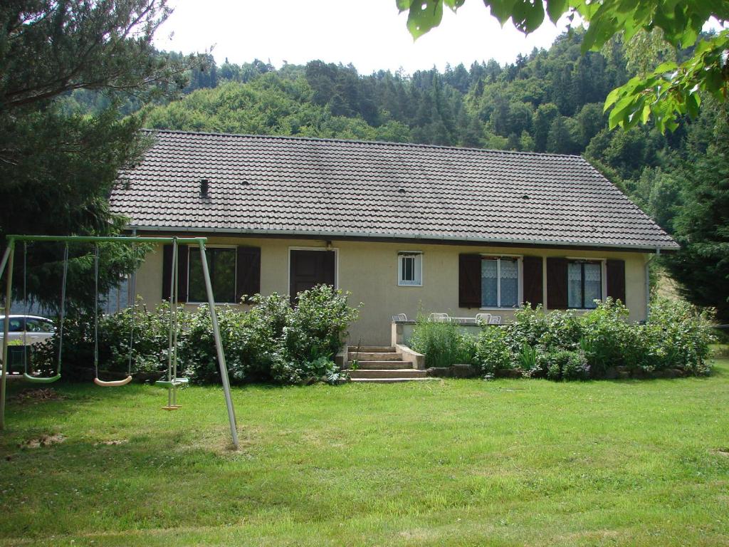 a house with a yard with a swing at Villa du Bac in Chambon-sur-Lac