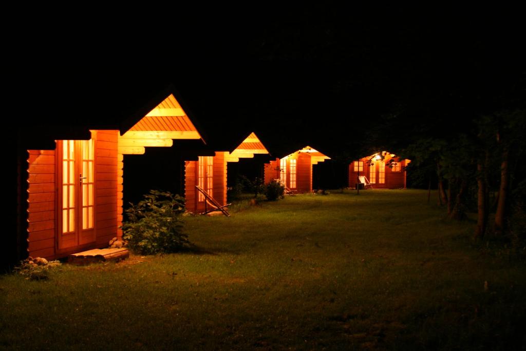 una fila de cabañas iluminadas por la noche en Uuskalda Sports and Holiday Village, en Kärbla