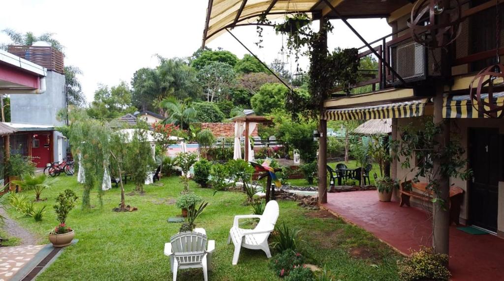 a garden with white chairs and tables in a yard at Apart Hotel Las Violetas in Candelaria