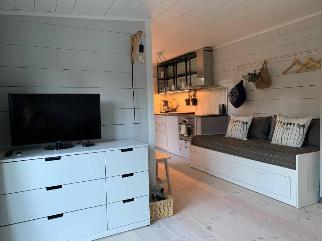 a living room with a couch with a tv on it at Mysigt gårdshus på vackra Stensö in Kalmar